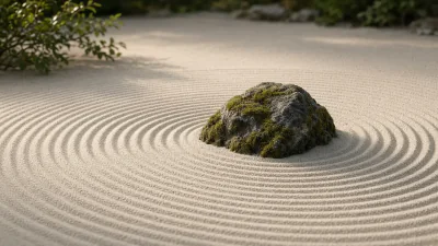 A mossy rock in raked sand with gentle circular lines